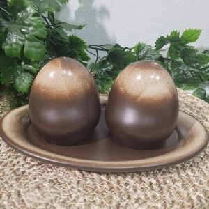 Ceramic salt and pepper shakers, with a matching saucer.